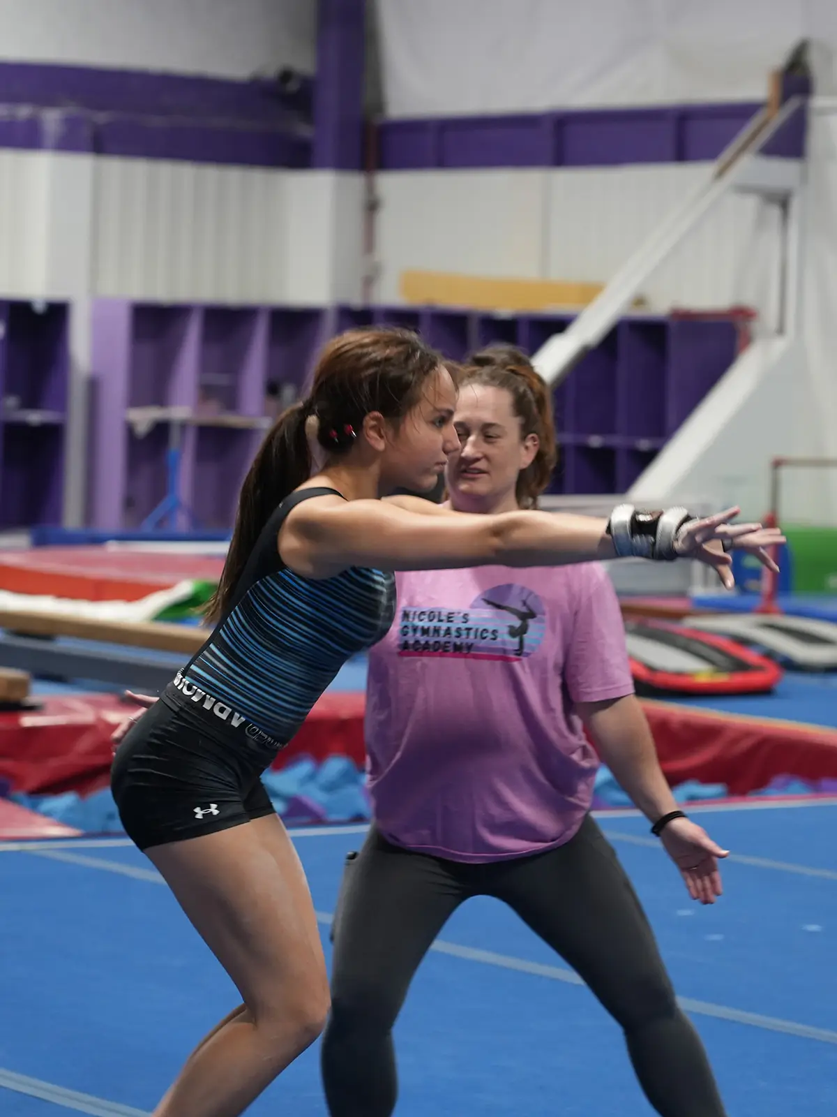 Nicole coaching a young gymnast on floor